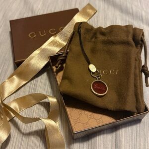 Vintage Gucci Gold-Tone Phone Charm with Red Enamel Medallion and Black Strap